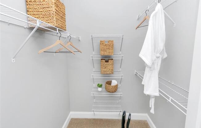 Walk-in closet with 3 long shelves on the side and 5 short stacked shelves in the back with baskets