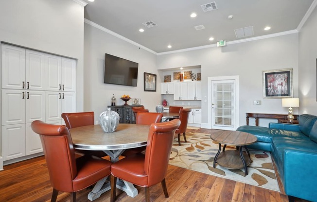 a living room with a table and chairs and a television