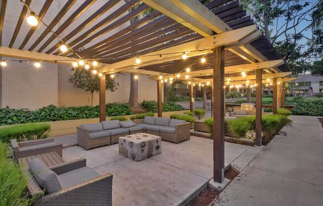 a patio with couches and a canopy with lights at Summerwood Apartments, Santa Clara