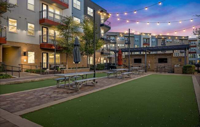 A patio with a table and chairs is surrounded by apartment buildings.