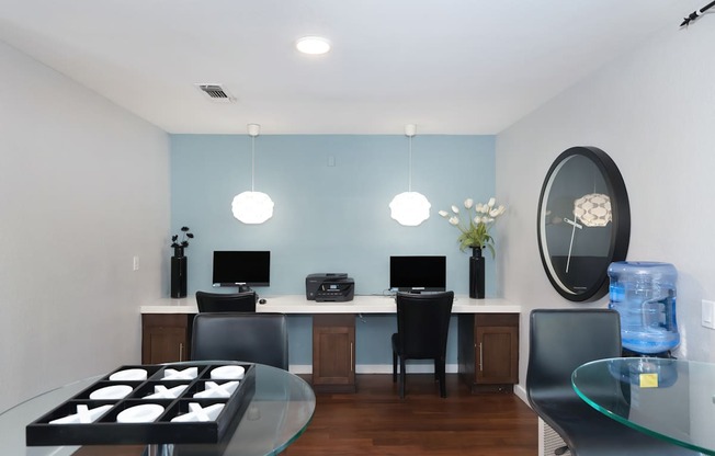 A modern home office with a glass table and a glass top coffee table.