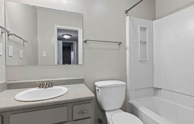 A bathroom with a toilet, sink, and bathtub.