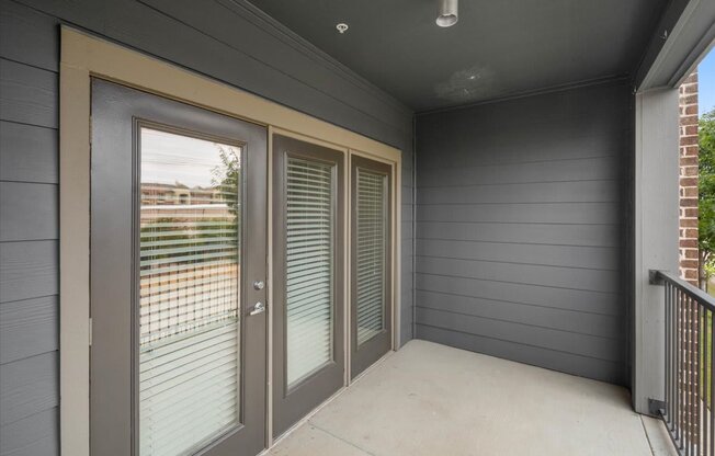 a patio with sliding glass doors and a balcony