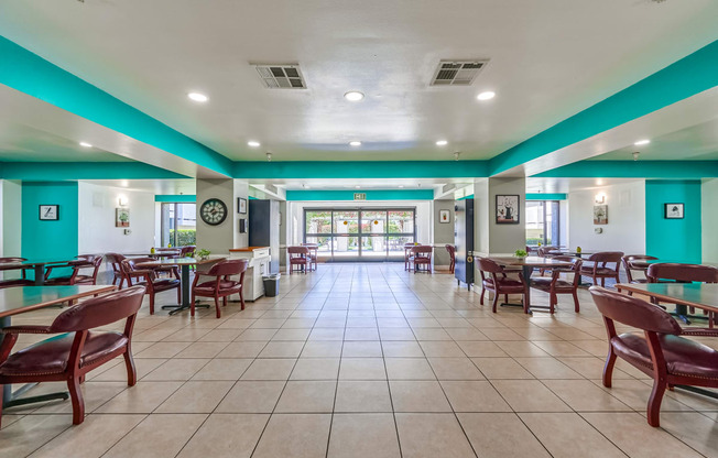 a dining area with tables and chairs and a clock on the wall