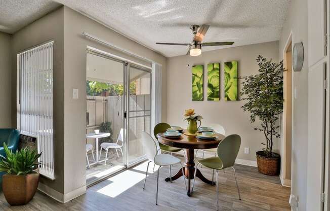 a dining room with a table and chairs and a sliding glass door