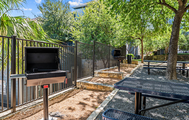 our community has a picnic area with a grill and trees