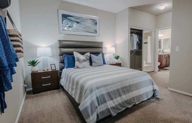 A bedroom with a large bed and a painting on the wall.