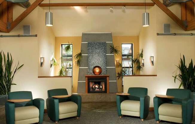 A living room with a fireplace and four chairs.