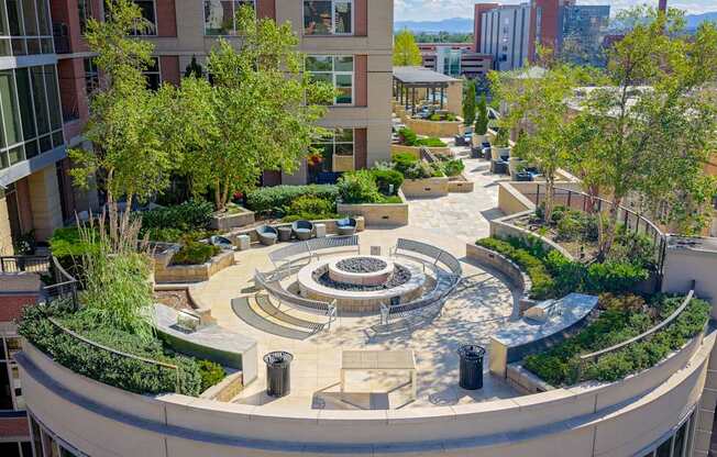 A circular courtyard surrounded by buildings with trees and benches.