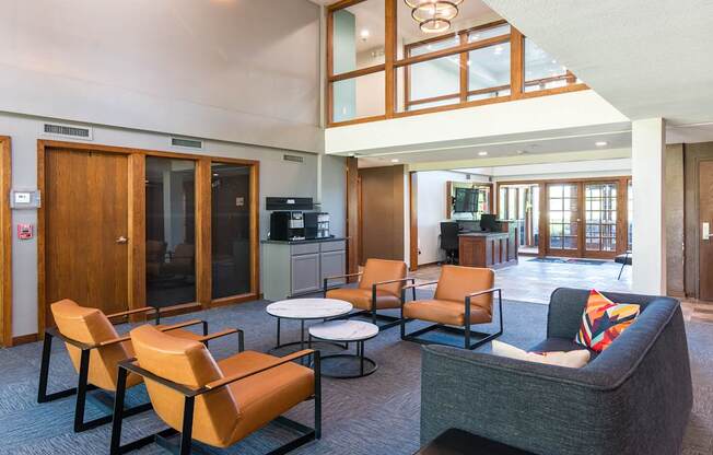 A living room with a grey couch and orange chairs.