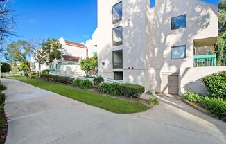 a white apartment building with a sidewalk in front of it  at Harvard Manor, Irvine, 92612
