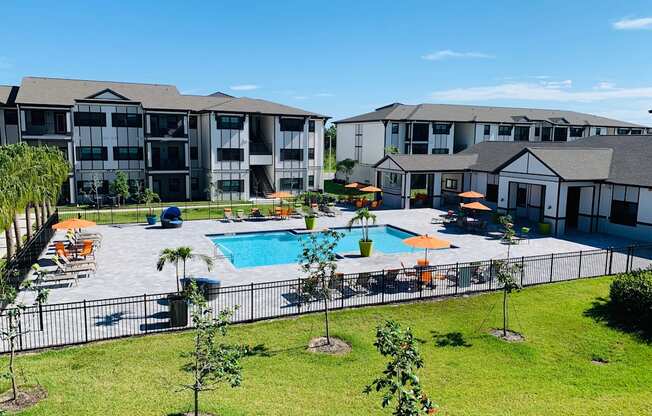 an aerial view of a swimming pool with apartments in the background