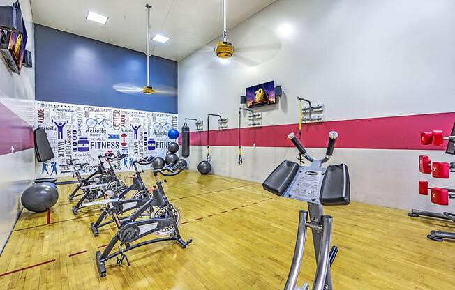 A gym with a variety of equipment including weights and exercise machines.