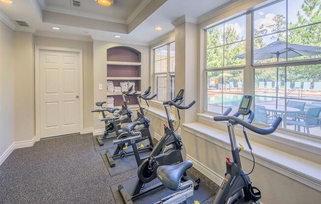 Premium fitness center with exercise equipment, padded flooring, tall windows, and high ceiling at Evergreen at Mahan in Tallahassee, FL