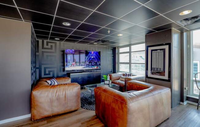 A living room with a brown leather sofa and a television.
