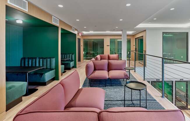 Cozy lounge with pink and green seating at The Mint Rahway, a luxury apartment rental near Rahway Train Station and Newark Airport.