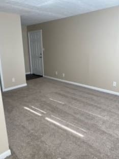 an empty living room with a door in it