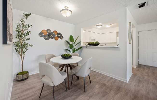 a dining room with a table and chairs    and a kitchen