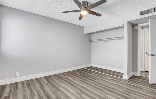 a bedroom with a ceiling fan and a closet