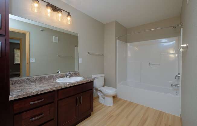 a bathroom with a sink and a toilet and a shower. Fargo, ND Urban Plains Apartments