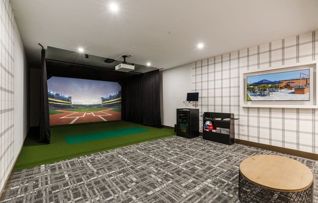 a living room with a large screen tv and a green rug at One Ten Apartments, Jersey City