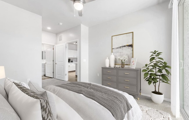 a bedroom with a large bed and a dresser with a plant on it