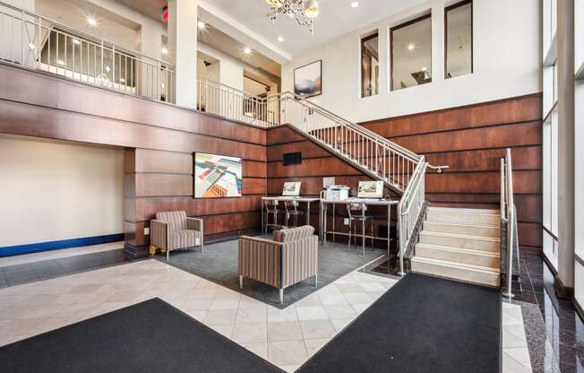 the lobby of a building with a staircase and chairs at Roosevelt Towers Apartments, Falls Church, Virginia