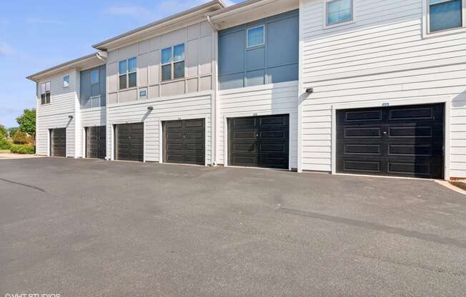 the front of a building with black garage doors