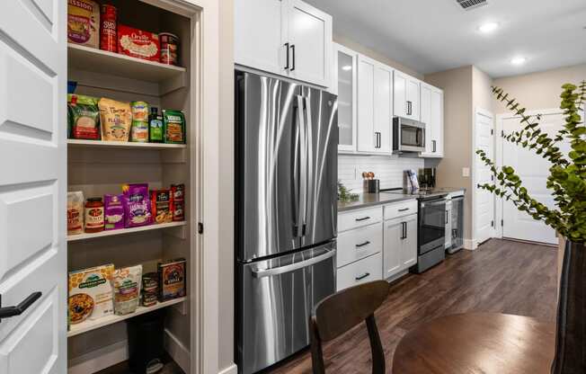 a kitchen with white cabinets and a stainless steel refrigerator