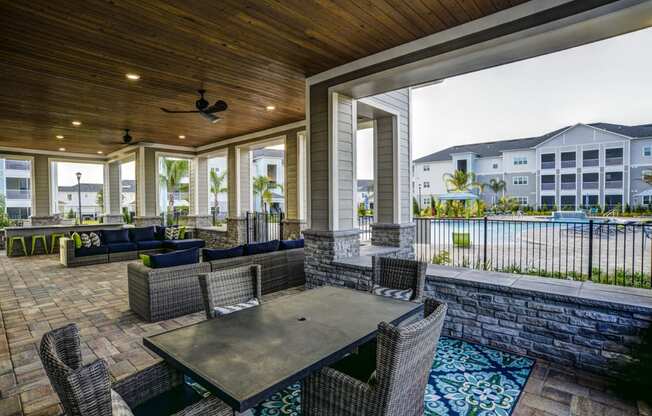 a patio area with tables and chairs and a porch