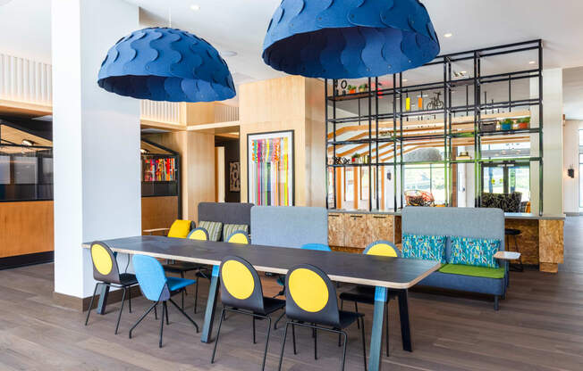 a dining room with blue chairs and a long table with chairs