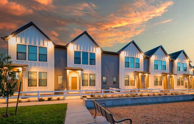 A row of houses with a bench in front of them.