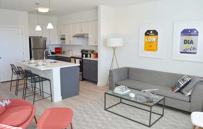 Model apartment kitchen with overhead lights, white counters and breakfast bar