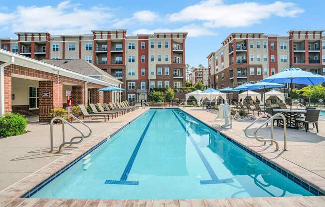 A long rectangular pool in front of apartment buildings.