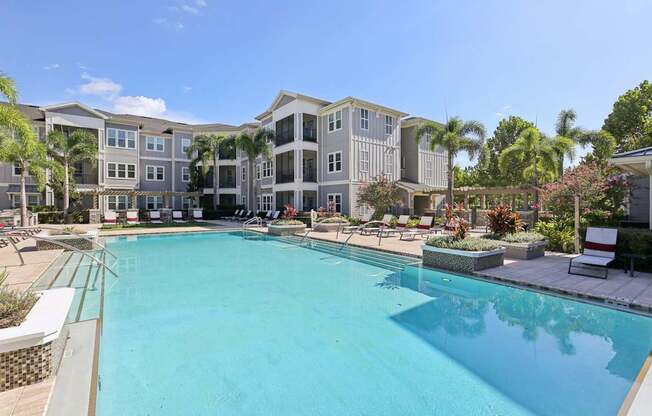 Swimming pool area with adjacent outdoor patio and shaded lounge chairs at Lotus at Starkey Ranch in Odessa, Florida