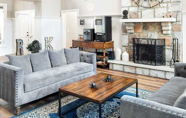 A grey couch sits in a living room with a wooden coffee table in front of it.