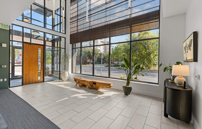 a lobby with large windows and a wooden bench