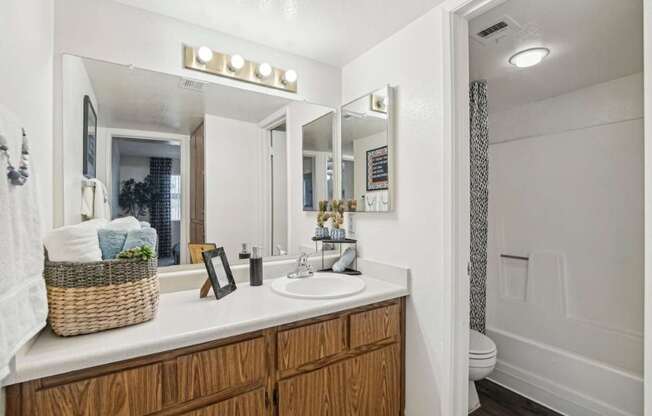 A bathroom with a white countertop and wooden cabinets.