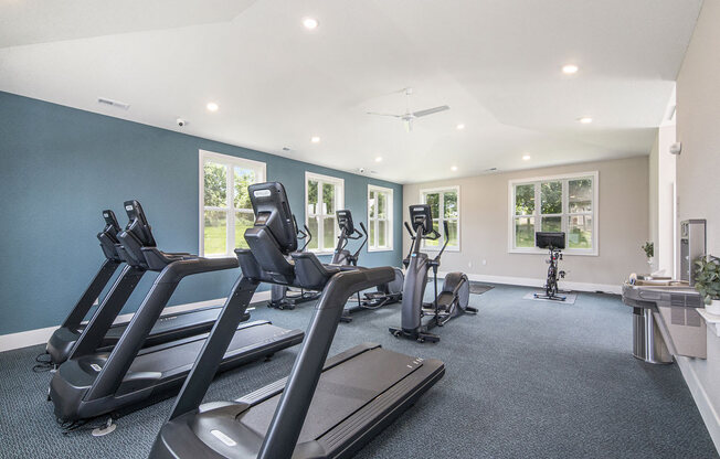 gym has plenty of cardio equipment and windows at The Crossings Apartments, Michigan, 49508