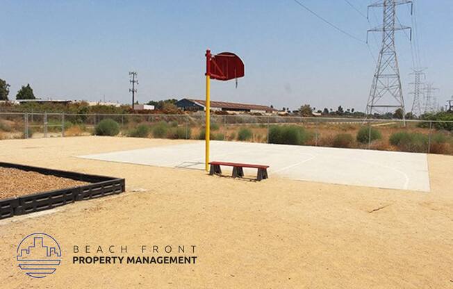 a basketball court with a bench and a flag in the dirt