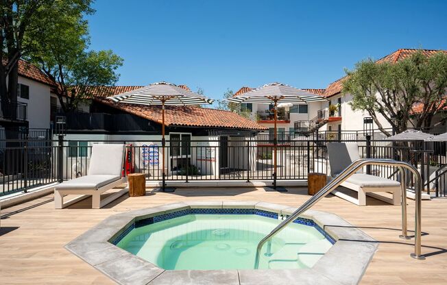 A small pool with a slide in the middle of a patio.