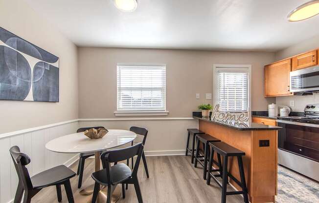 A kitchen with a table and chairs.