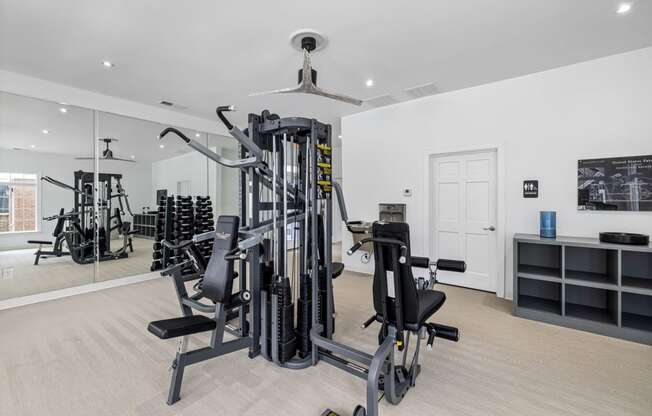 a gym with weights and cardio equipment in a home with a glass door