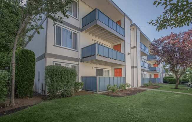 Tukwila, WA Apartments - Foster Creek - Exterior View of Apartment Building with Balconies Surrounded by Lush Landscaping