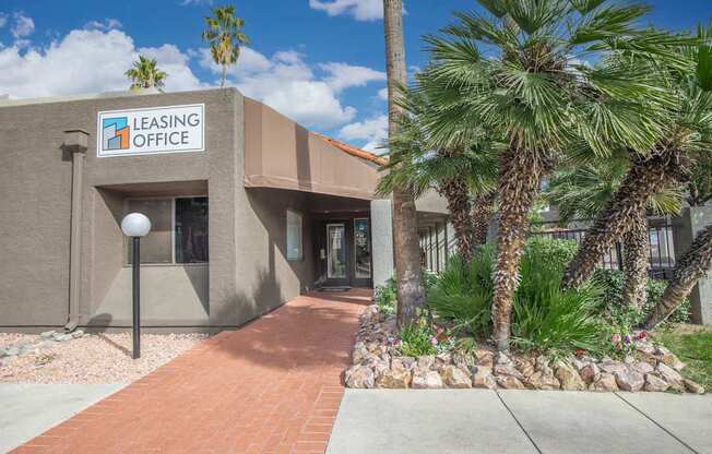 A leasing office building with a brick pathway leading to the entrance.