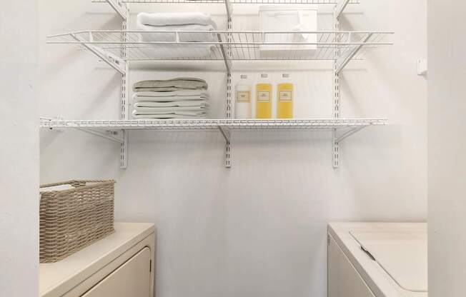 a laundry room with a sink and a shelf with towels