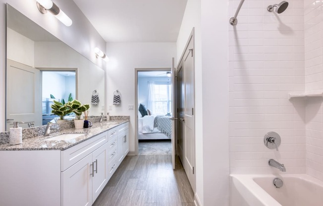 a white bathroom with a shower and a sink and a tub