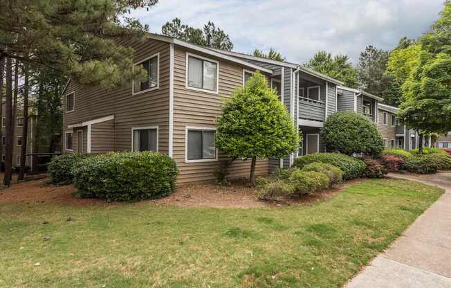 A row of houses with green bushes in front.