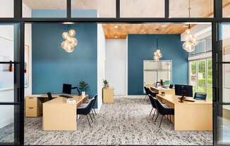 a large office with desks and chairs and a blue wall