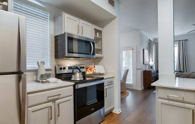 a kitchen with white cabinets and stainless steal appliances